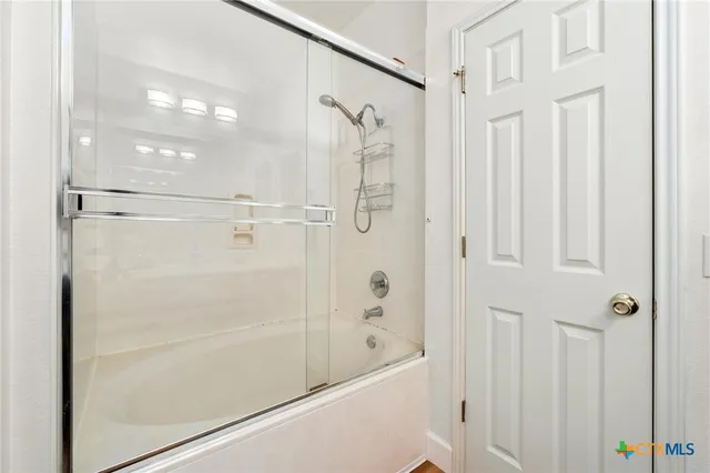 a bathroom with a glass shower door