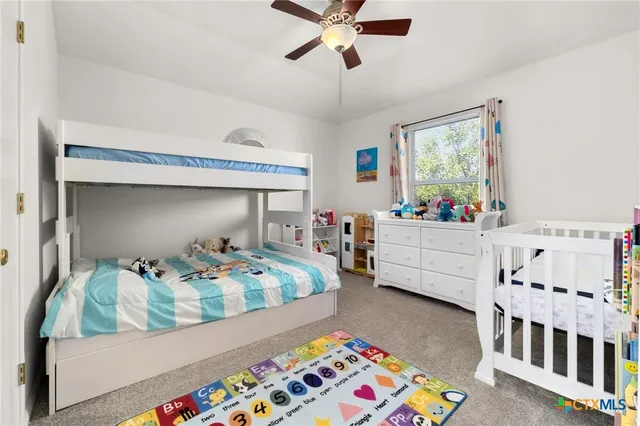 a bedroom with furniture a baby crib and a window
