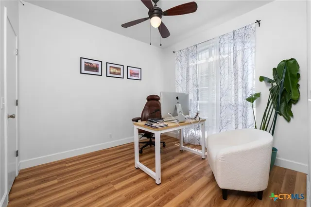 a view of a workspace with furniture and a window