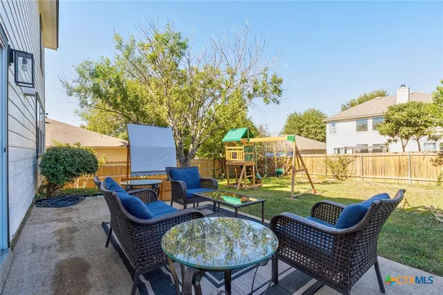 a view of a patio with couches table and chairs and potted plants