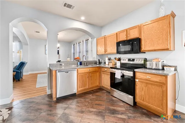 a kitchen with a sink cabinets and stainless steel appliances