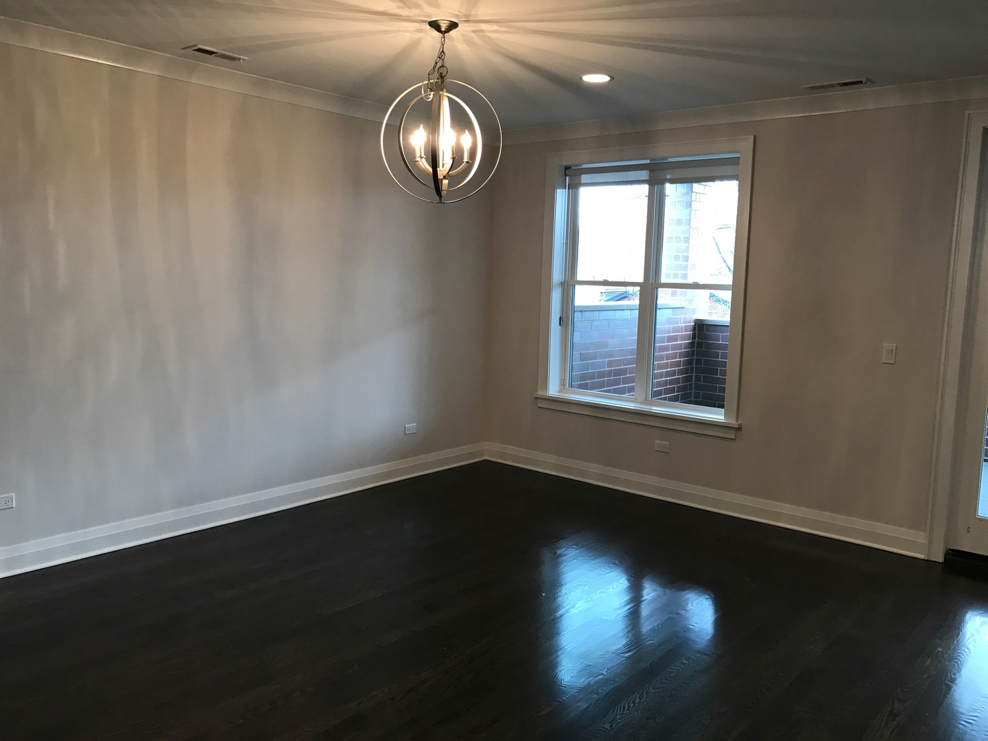 1843 West Irving Park Road, Unit 3 Chicago, IL 60613 - Photo 19 of 34 a view of an empty room with wooden floor and a window