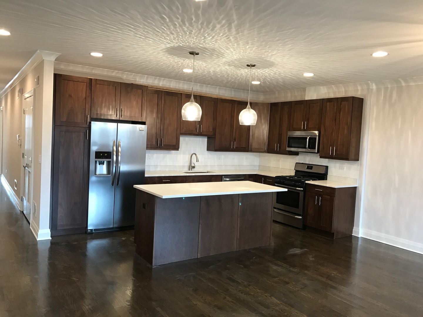 1843 West Irving Park Road, Unit 3 Chicago, IL 60613 - Photo 2 of 34 a large kitchen with stainless steel appliances wooden floors and wooden cabinets