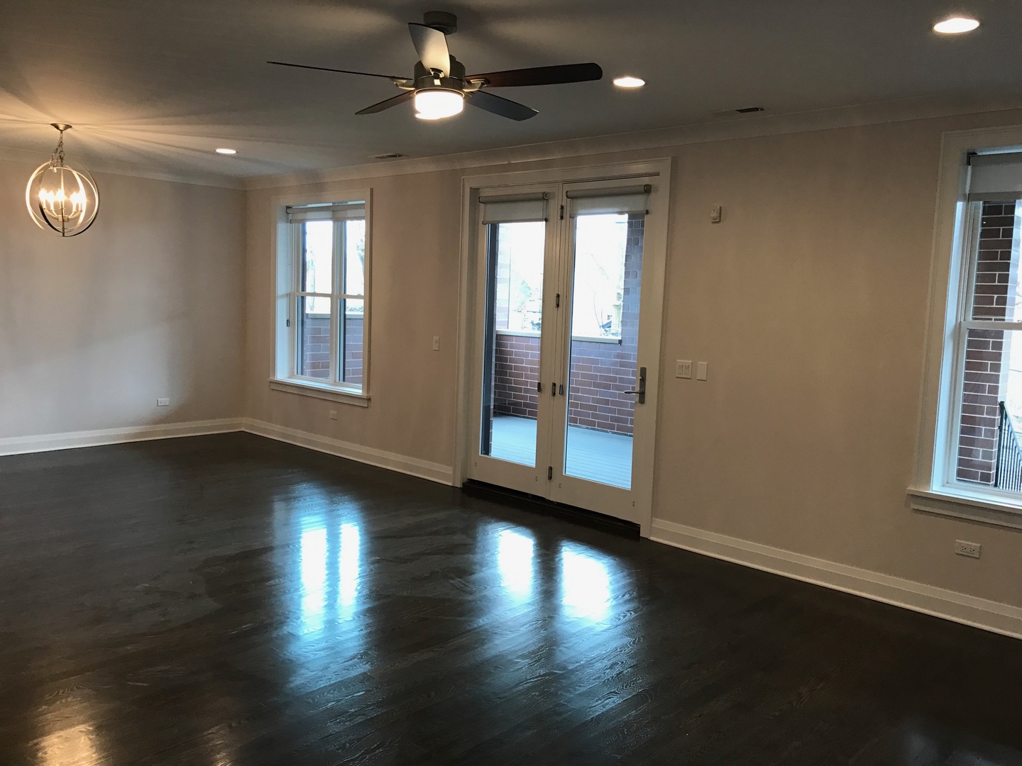 1843 West Irving Park Road, Unit 3 Chicago, IL 60613 - Photo 21 of 34 an empty room with wooden floor and windows with curtains
