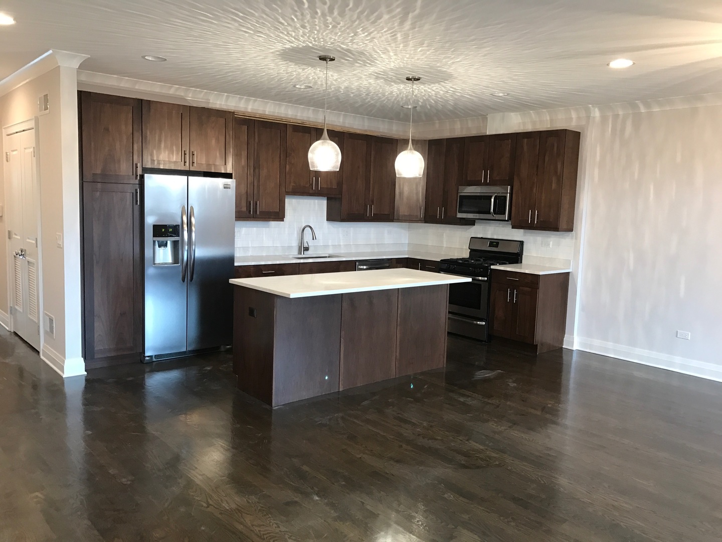 1843 West Irving Park Road, Unit 3 Chicago, IL 60613 - Photo 3 of 34 a kitchen with stainless steel appliances granite countertop a sink a stove and a refrigerator