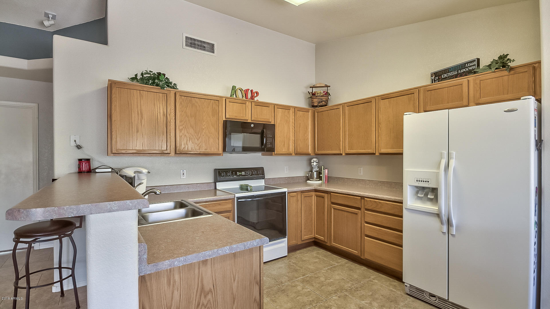 2001 South Mountain View Road Apache Junction, AZ 85119 - Photo 8 of 46 a kitchen with stainless steel appliances granite countertop a sink stove refrigerator and cabinets