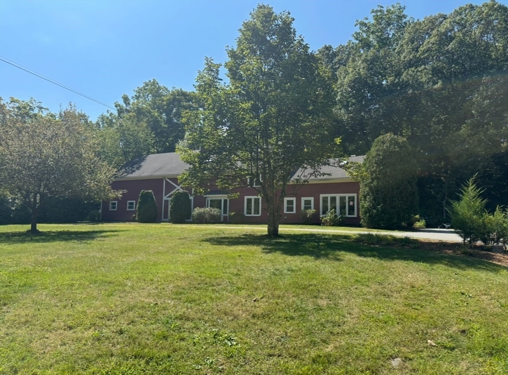 a front view of a house with a yard and trees