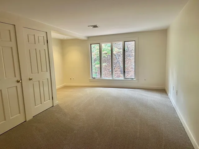 an empty room with windows and closet