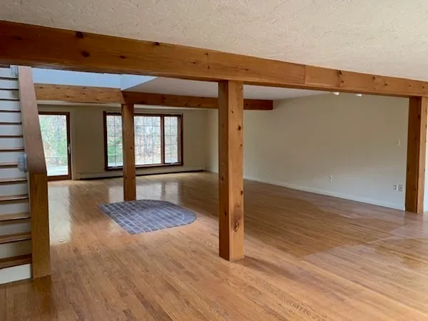 a view of a hallway with wooden floor and staircase