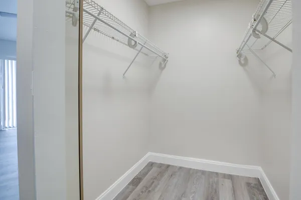 an empty room with windows and ceiling fan