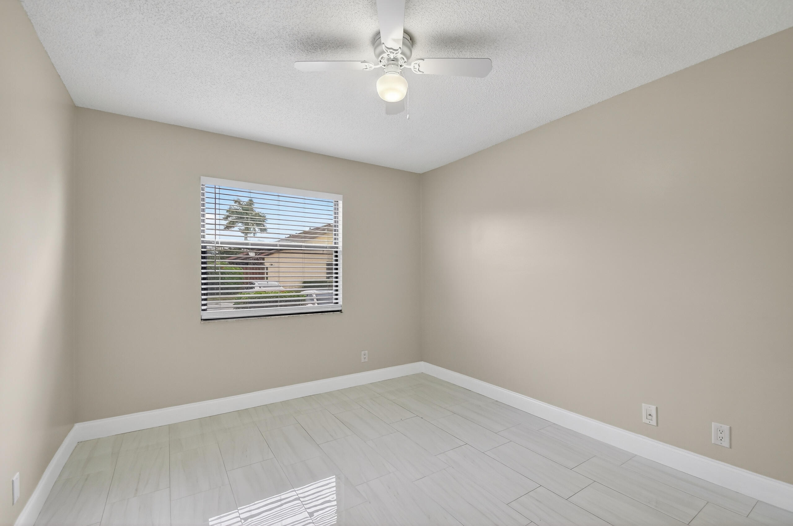 484 Springdale Circle, Unit 48D Palm Springs, FL 33461 - Photo 31 of 59 an empty room with windows and ceiling fan
