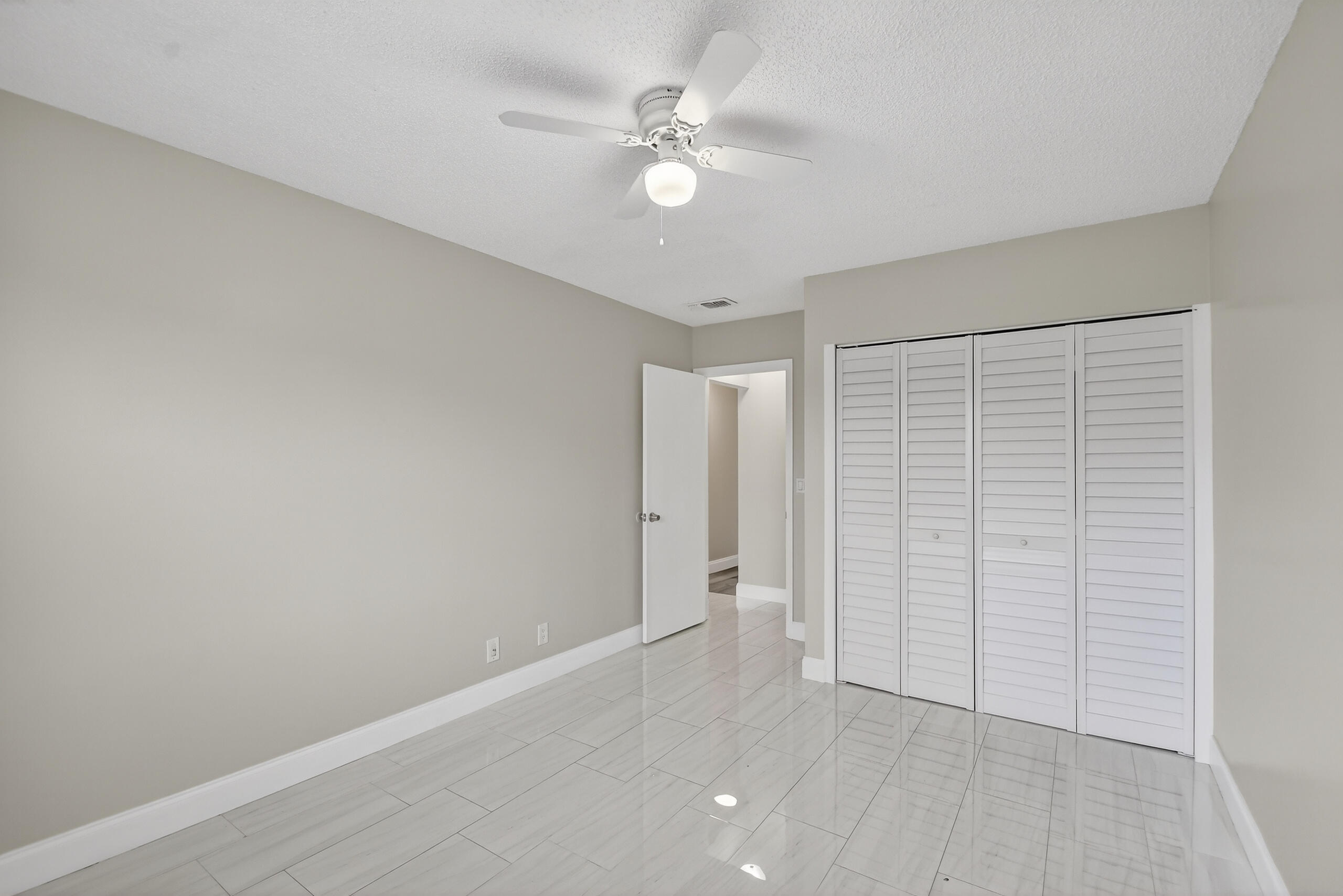 484 Springdale Circle, Unit 48D Palm Springs, FL 33461 - Photo 32 of 59 an empty room with closet and fan