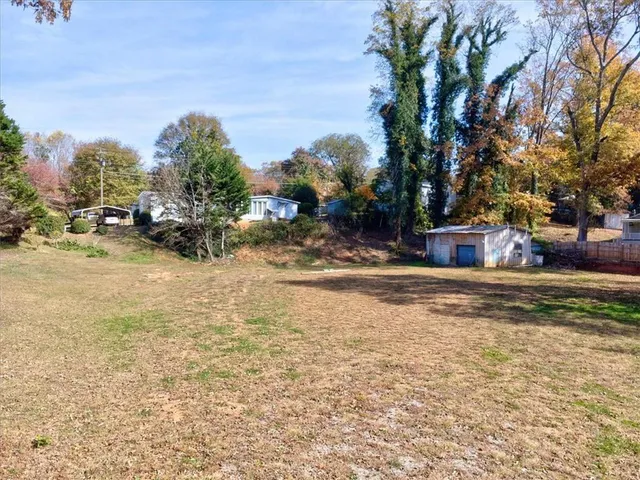 a view of a yard with cars on road