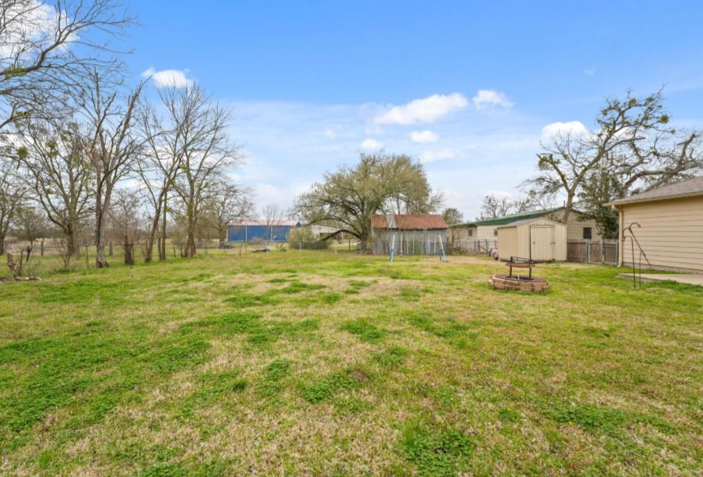 209 Mill Street Lone Oak, TX 75453 - Photo 26 of 29 View of yard featuring an outbuilding, fence, a fire pit, and a shed