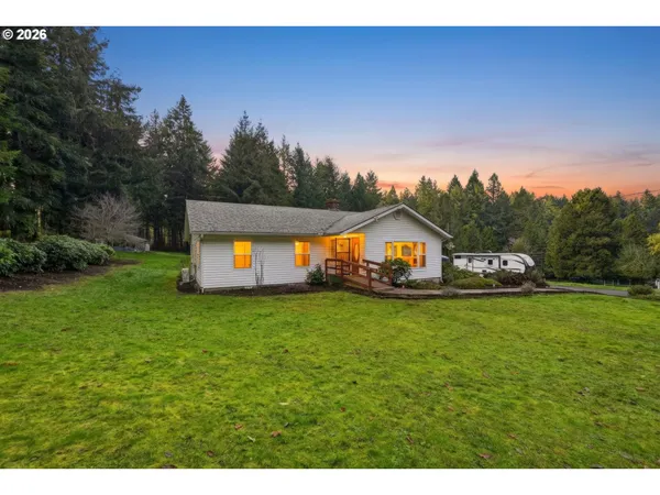 a house with green field in front of it