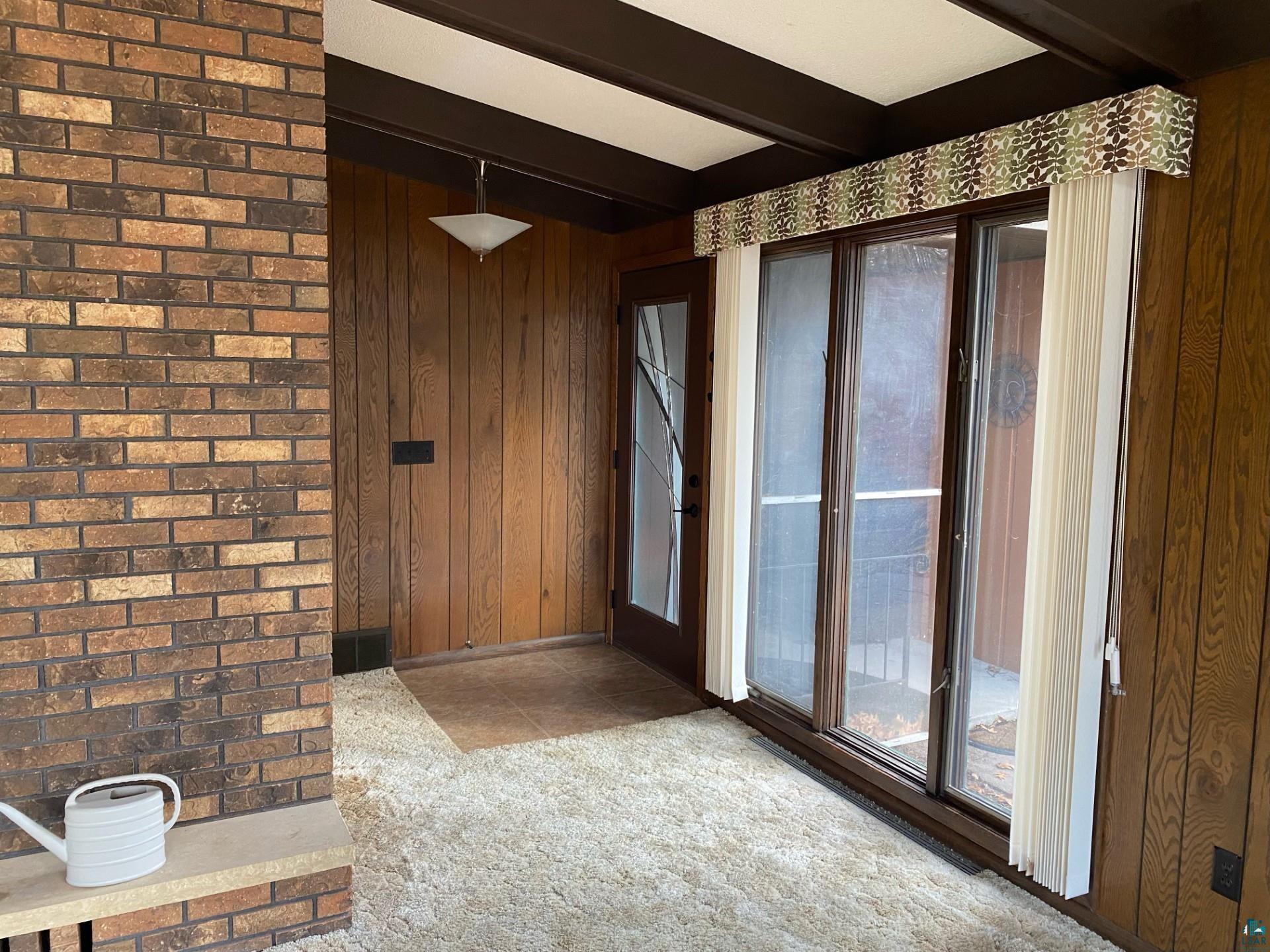 11316 East Timber Ridge Drive Lake Nebagamon, WI 54849 - Photo 13 of 27 Entryway featuring wood walls, beamed ceiling, and carpet