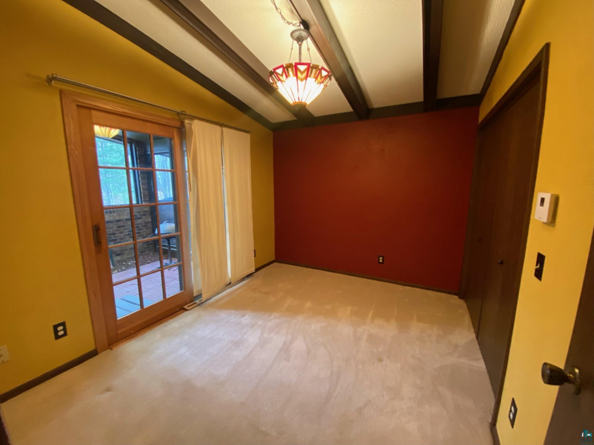 11316 East Timber Ridge Drive Lake Nebagamon, WI 54849 - Photo 17 of 27 Carpeted empty room featuring lofted ceiling with beams