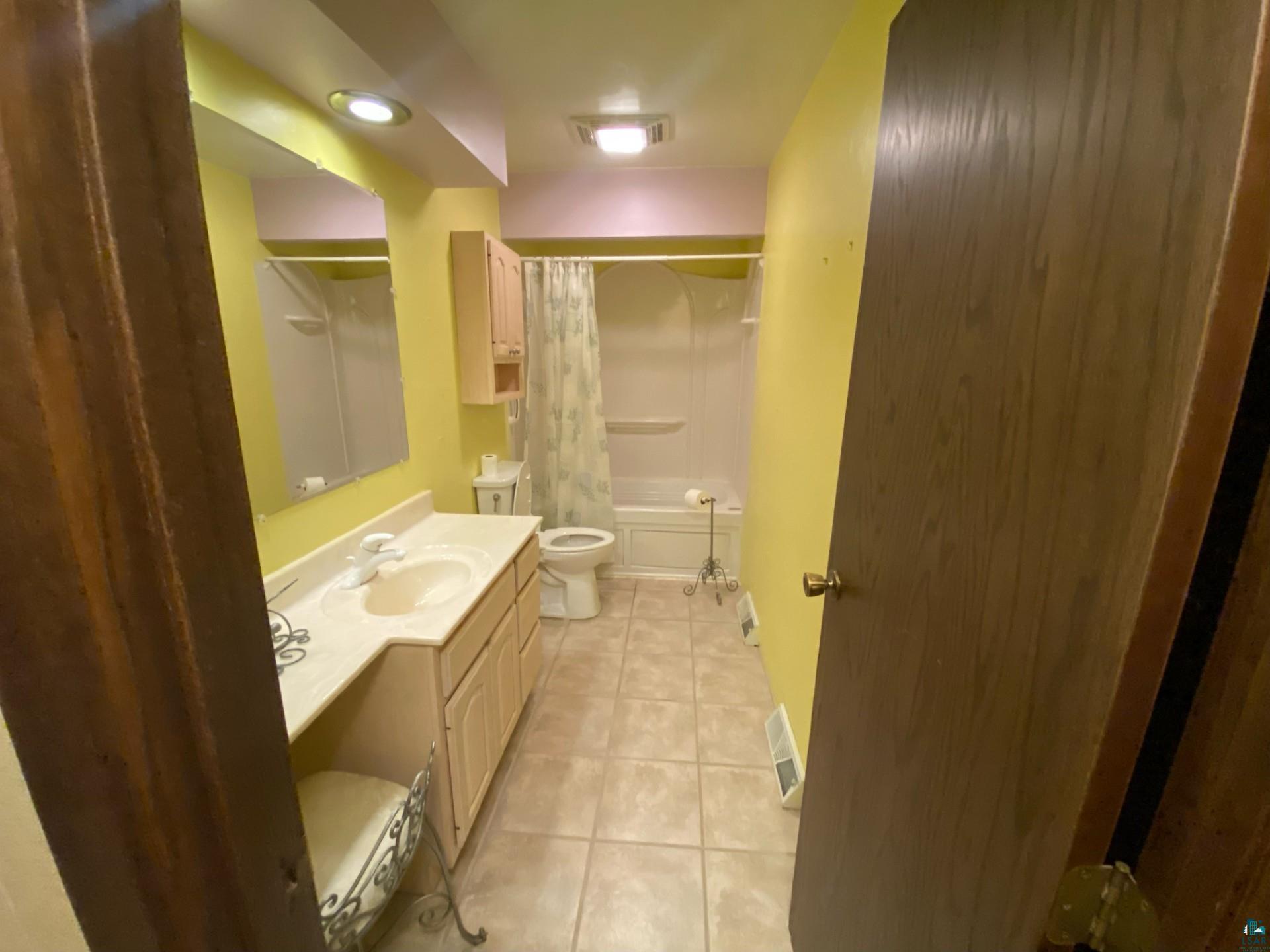 11316 East Timber Ridge Drive Lake Nebagamon, WI 54849 - Photo 19 of 27 Full bathroom with vanity, tile patterned floors, toilet, and shower / tub combo