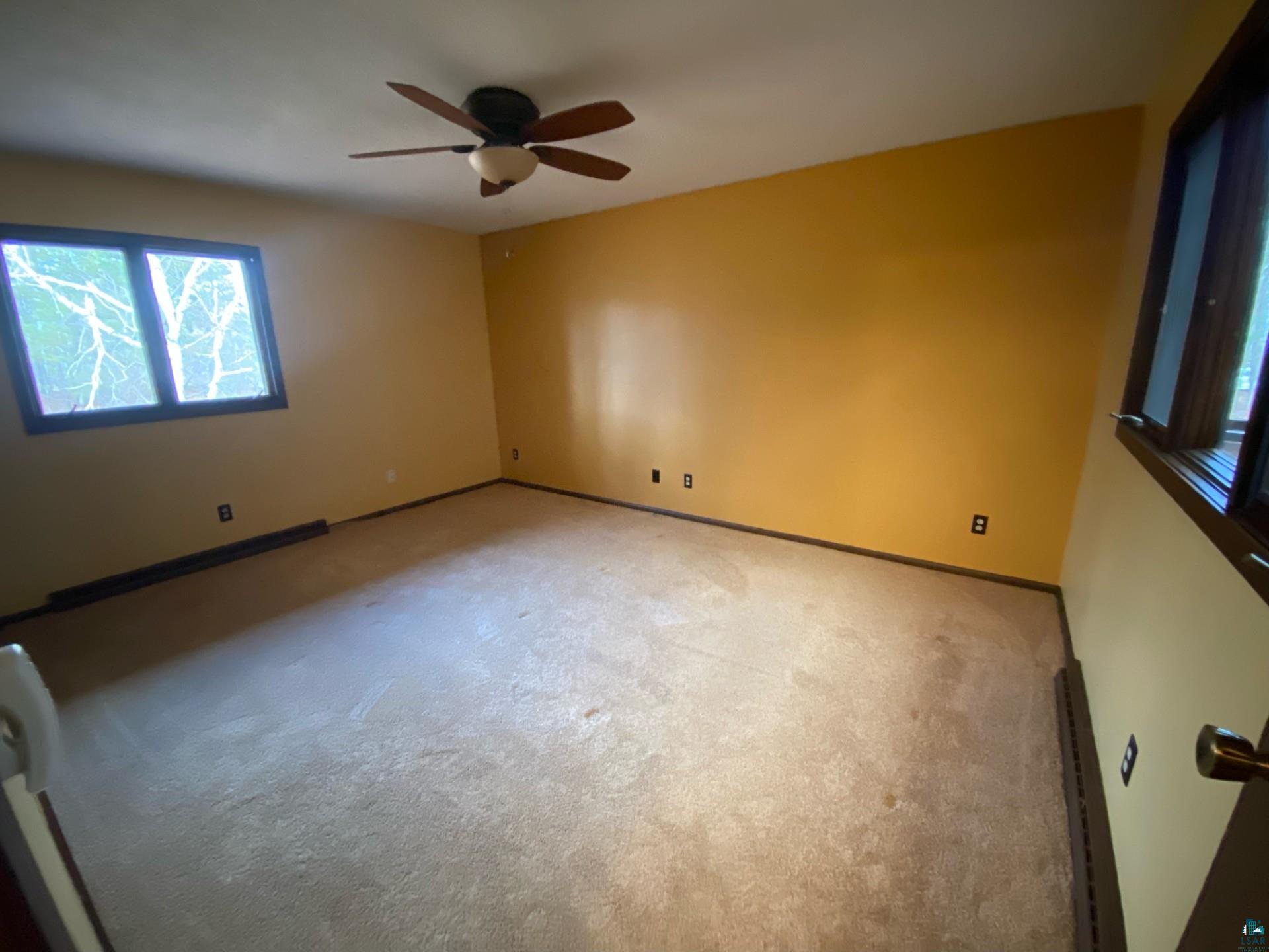 11316 East Timber Ridge Drive Lake Nebagamon, WI 54849 - Photo 20 of 27 Carpeted empty room featuring ceiling fan and a baseboard radiator