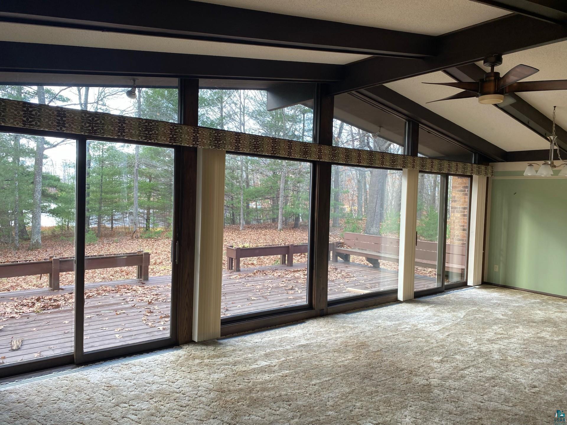 11316 East Timber Ridge Drive Lake Nebagamon, WI 54849 - Photo 6 of 27 Doorway featuring a wealth of natural light, ceiling fan, vaulted ceiling with beams, and carpet floors