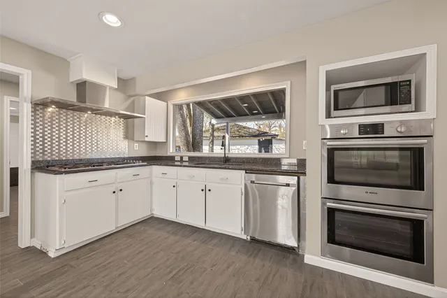 a kitchen with granite countertop a sink and a stove top oven