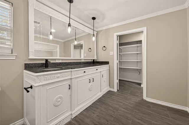 a large kitchen with a sink and a refrigerator