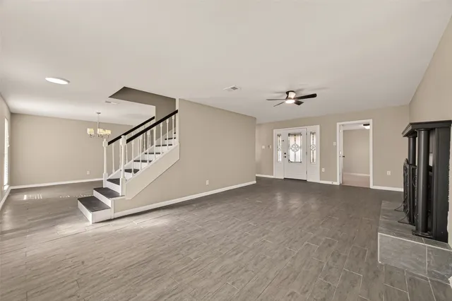 a view of an empty room with stairs and a window