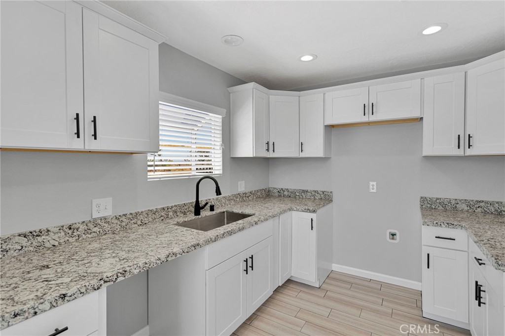 11076 Wagon Train Road Pinon Hills, CA 92371 - Photo 11 of 24 a kitchen with granite countertop white cabinets white appliances and a granite counter tops