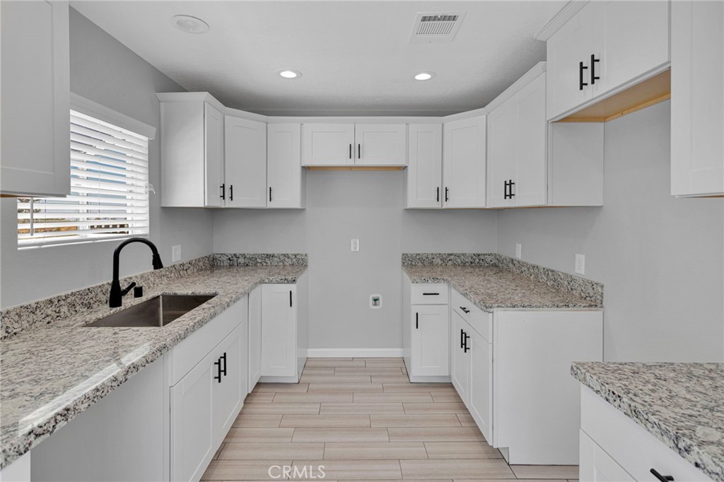 11076 Wagon Train Road Pinon Hills, CA 92371 - Photo 12 of 24 a kitchen with granite countertop a sink and cabinets