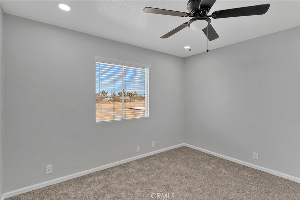 11076 Wagon Train Road Pinon Hills, CA 92371 - Photo 16 of 24 an empty room with a window and a fan