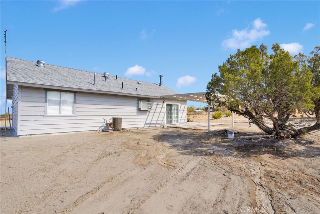 11076 Wagon Train Road Pinon Hills, CA 92371 - Photo 22 of 24 a view of a house with a backyard and a garage