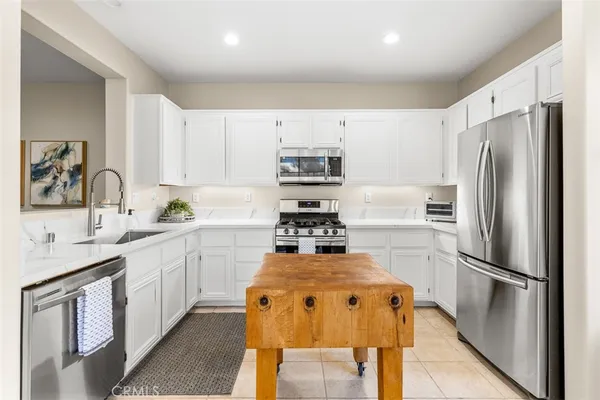 a kitchen with refrigerator a sink and white cabinets