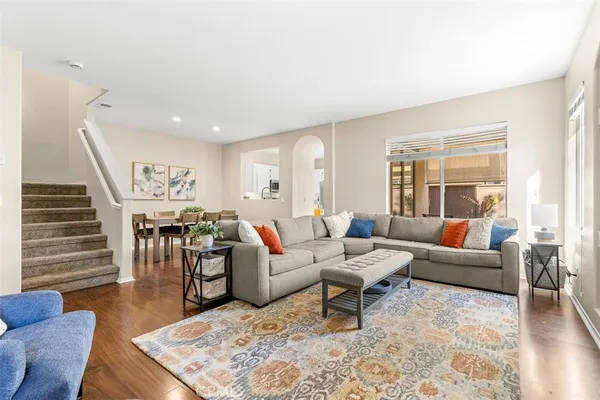 a living room with furniture wooden floor and window