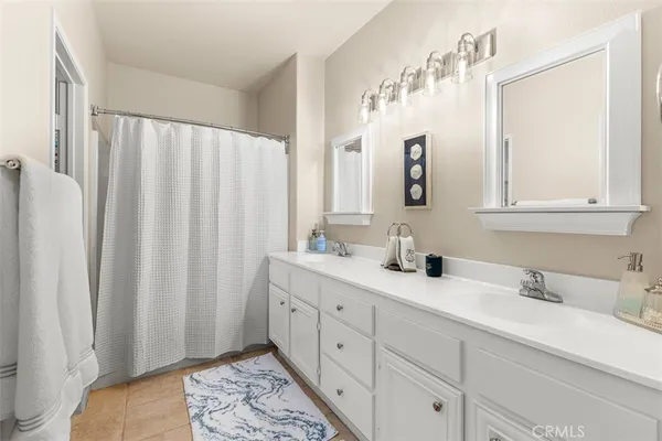 a bathroom with double vanity sink a mirror and a shower