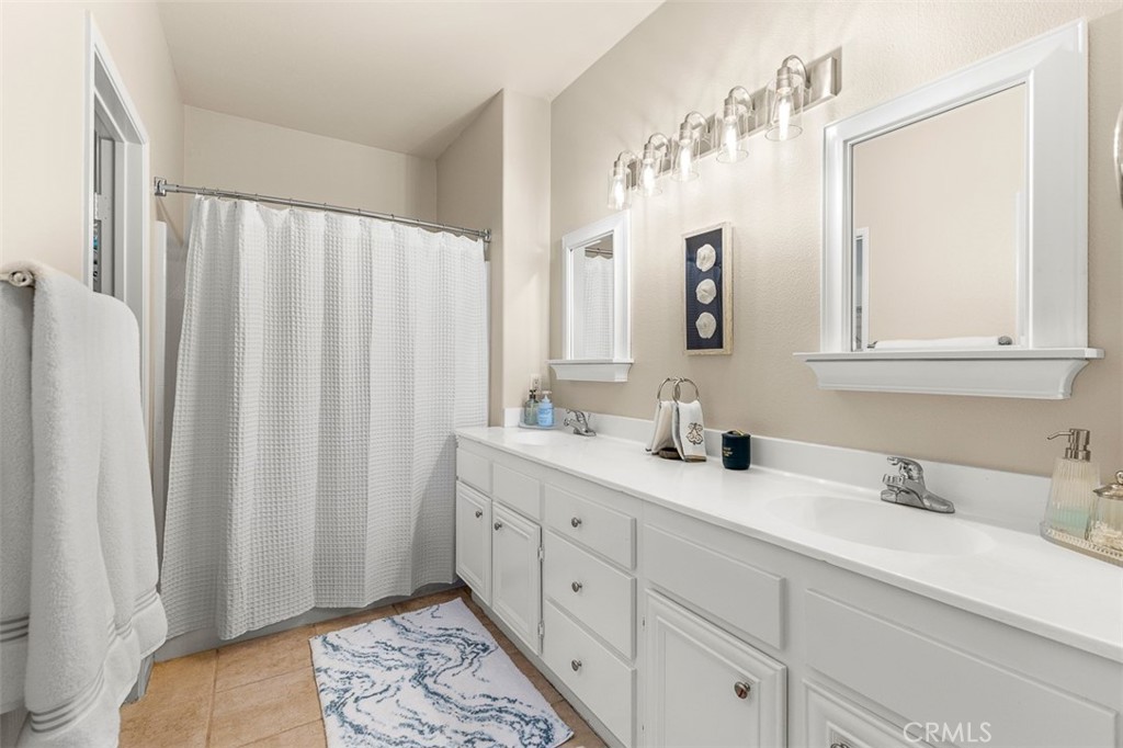 638 Sumner Way Oceanside, CA 92058 - Photo 9 of 17 a bathroom with double vanity sink a mirror and a shower