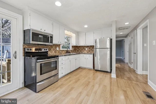 a kitchen with stainless steel appliances a stove a sink and a refrigerator