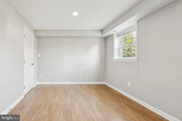 a view of empty room with wooden floor and window