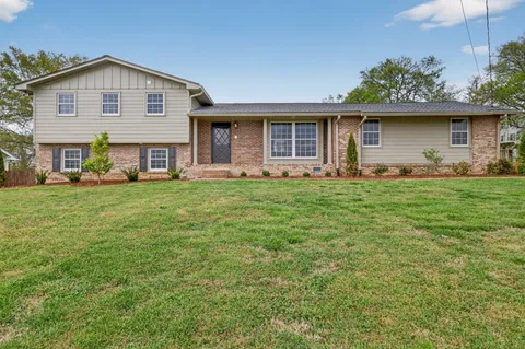 a front view of a house with a yard and outdoor seating