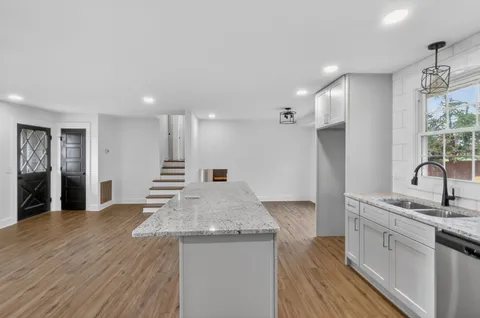 a kitchen with a stove and a wooden floors
