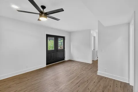 an empty room with a window and a fan