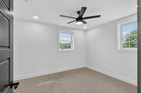 an empty room with a window and a fan