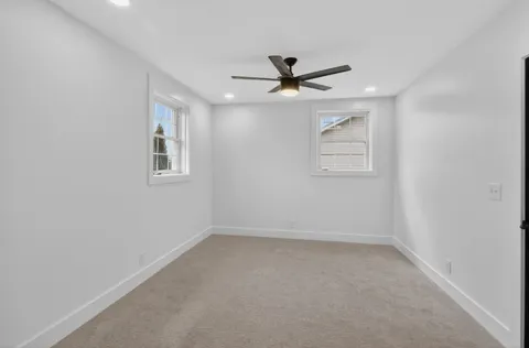 an empty room with closet and a ceiling fan