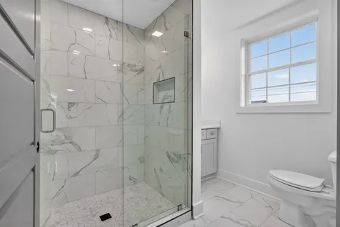 a bathroom with a shower a toilet and sink