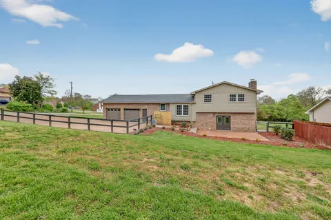 a view of an empty room with a fireplace and a garage