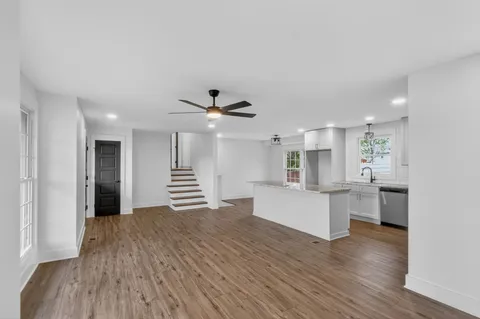 a view of a livingroom with wooden floor and a ceiling fan