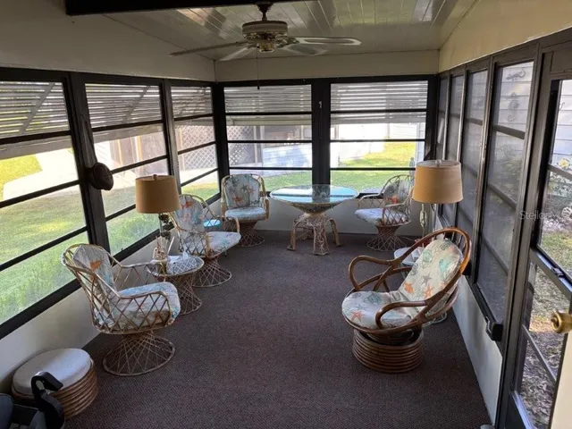 a living room with furniture and a floor to ceiling window
