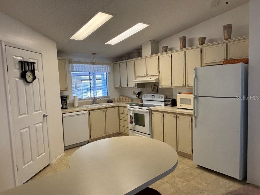 617 Webb Way Lady Lake, FL 32159 - Photo 5 of 15 a kitchen with white cabinets and white appliances