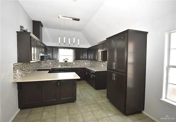 a kitchen with a sink refrigerator and cabinets