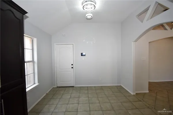 a view of an empty room with windows and bathroom
