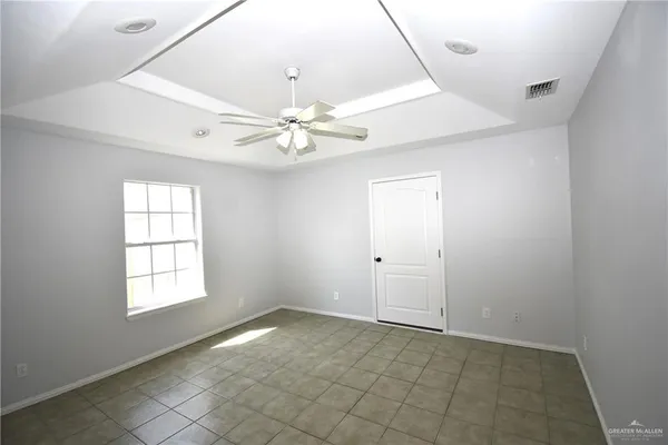 an empty room with windows and fan